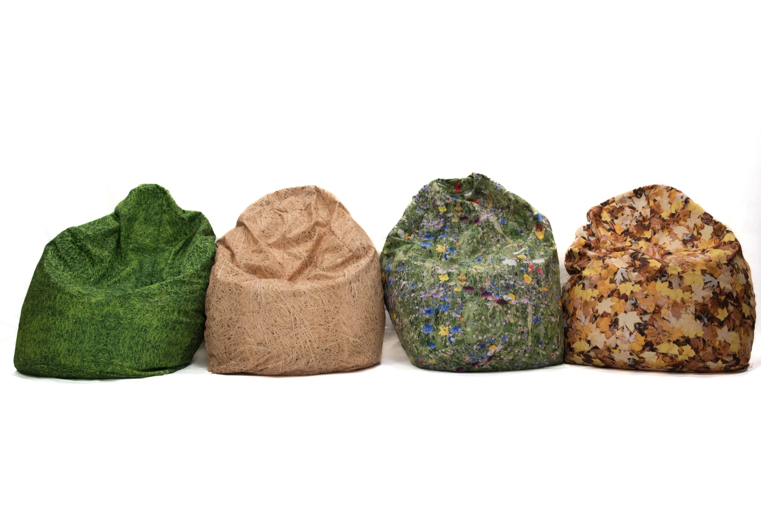 Four nature-print bean bags in grass, hay, meadow and autumn leaves prints lined up against a white background.